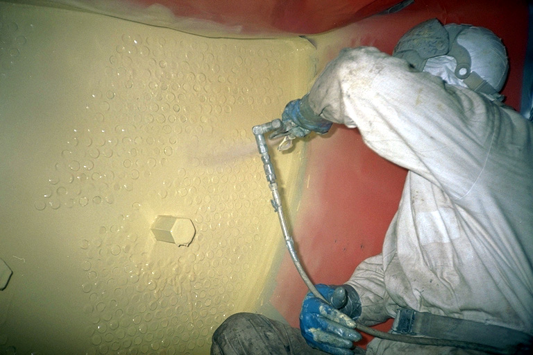 Trained operative applying a protective steel coating